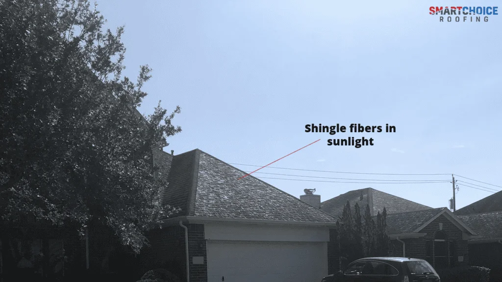 Roof shingles reflecting sunlight on house.