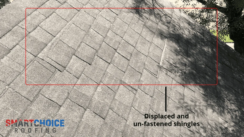 Roof with displaced and unfastened shingles.